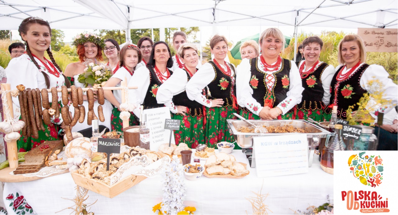 Kóło Gospodyń Wiejskich - Kobiety w strojach ludowych stojące za stołem z jedzeniem lokalnym